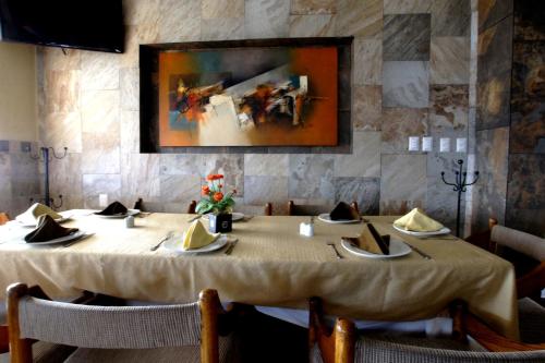 a dining room with a table and a painting on the wall at Hotel Marbella in Manzanillo