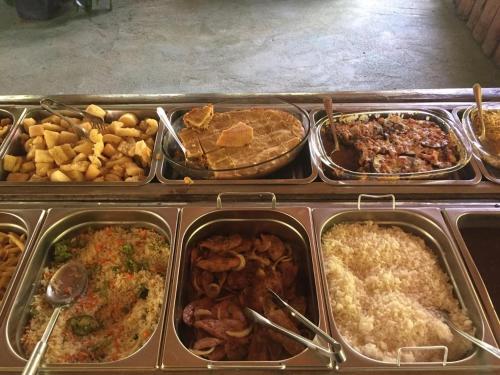 a buffet of different types of food in trays at Solo Sagrado in Bom Jardim