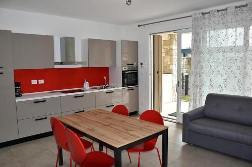a kitchen with a wooden table and red chairs at Villetta Pima in Garda