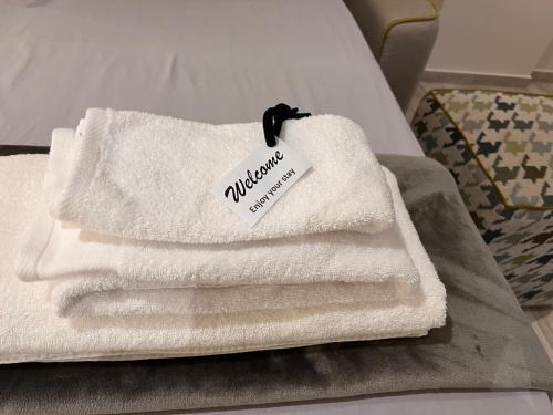 una pila de toallas sentadas encima de una cama en Roma Suite Trastevere Railway Station en Roma