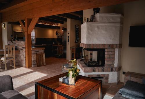 a living room with a stone fireplace and a table at Fließ Paradies mit Blockbohlensauna in Leipe