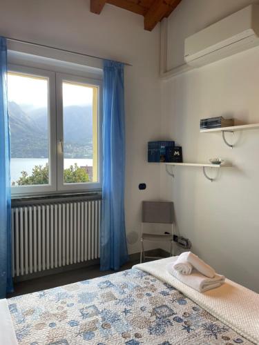 a bedroom with a bed and a large window at Casa delle Olive 1 in Oliveto Lario