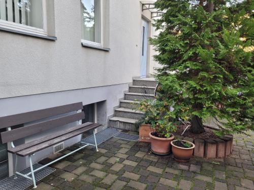 a bench in front of a house with a tree at Ferienwohnung Mira in Cottbus