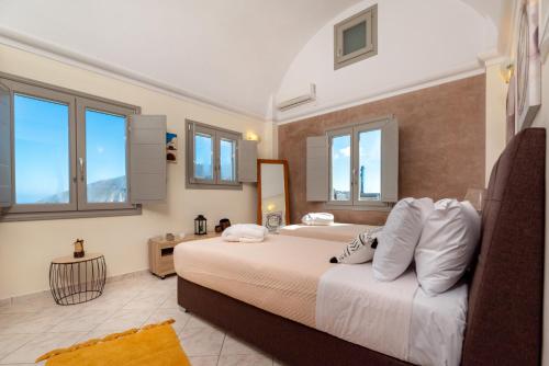 a bedroom with a large bed and windows at Horizon Sky House with view in Pirgos