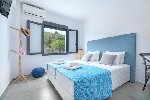 a bedroom with a large bed and a window at Mythos Luxury Villa-Skiathos in Troulos