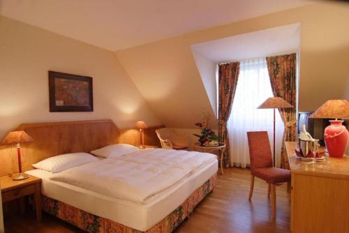 a bedroom with a large white bed in a room at Hotel Lübecker Hof in Lübeck