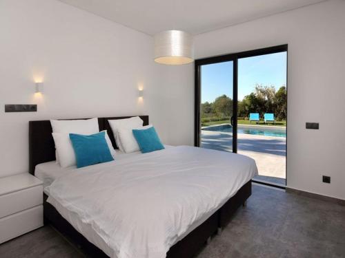 a bedroom with a large white bed with blue pillows at Luxurious Algarve Villa Villa Manou 5 Bedrooms Private Heated pool 300m from the Beach Carvoeiro in Carvoeiro