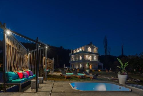 特勞洛斯的住宿－Mythos Luxury Villa-Skiathos，一座房子,在晚上前设有一个游泳池