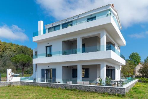 una casa bianca con molte finestre di Mythos Luxury Villa-Skiathos a Troulos