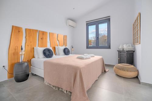 a bedroom with a bed with a table and a window at Mythos Luxury Villa-Skiathos in Troulos