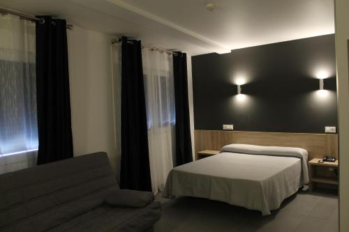 a hotel room with a bed and a couch at Hotel Hollywood in Cangas de Morrazo