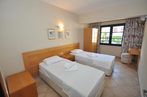 a hotel room with two beds and a window at Sun Blue Apart Hotel in Marmaris