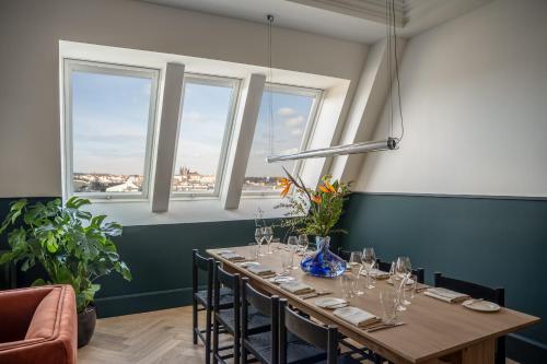 a long table in a room with windows at Almanac X Alcron Prague in Prague