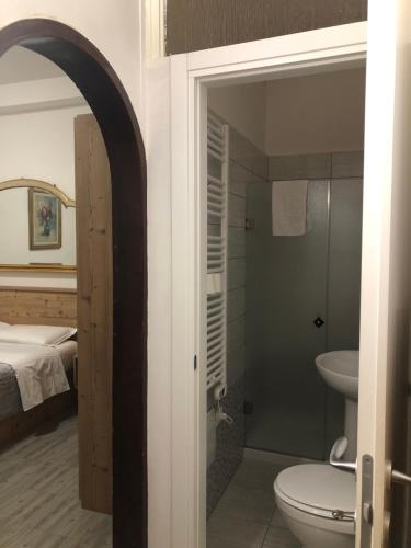 a bathroom with a toilet and a sink and a bed at Casa Mia in Verona