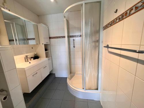 ein Bad mit einer Dusche und einem Waschbecken in der Unterkunft Reumann Holiday Apartments: De Schelp in Zandvoort