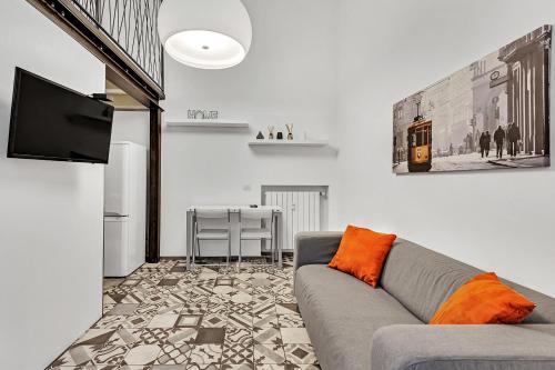 uma sala de estar com um sofá e uma televisão de ecrã plano em Loft Spritz em Milão