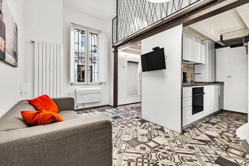 uma sala de estar com um sofá e uma cozinha em Loft Spritz em Milão