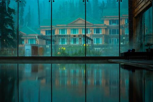a building is seen through the windows of a building at The Khyber Himalayan Resort & Spa in Gulmarg