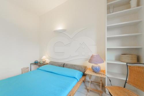 a bedroom with a bed and a table with a lamp at Villa il Cappero View & Beach - Goelba in Procchio