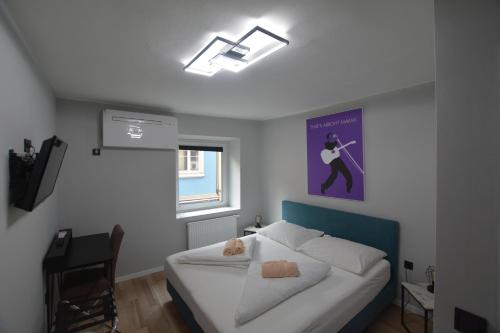 ein Schlafzimmer mit einem Bett und einem Wandgemälde in der Unterkunft Stadthotel Das Villach in Villach