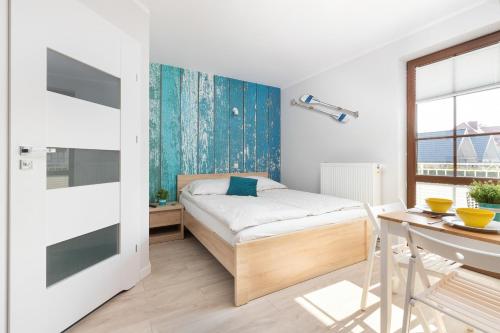 a small bedroom with a bed and a desk at Liliowa Seaside Apartments by Renters in Dębki