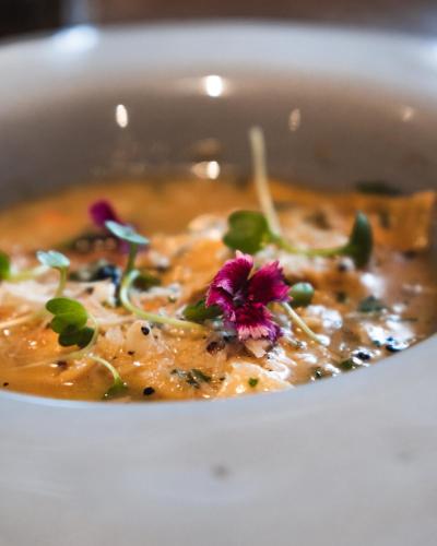 a bowl of soup with a flower in it at The Khyber Himalayan Resort & Spa in Gulmarg