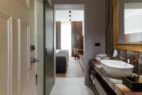 a bathroom with a white sink and a mirror at Hotel Švicarija - Terme Dobrna in Dobrna