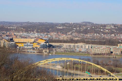 a yellow bridge over a river next to a city at Refined Studio New Construction 1 Mile From Town in Pittsburgh
