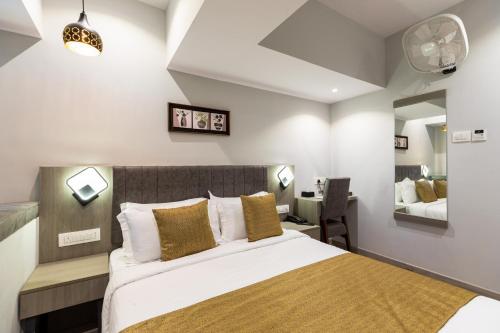 a bedroom with a large bed and a desk at Hotel Larmont Luxury in Mumbai