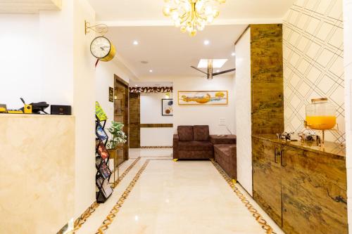 a hallway with a couch and a clock on the wall at Hotel Larmont Luxury in Mumbai