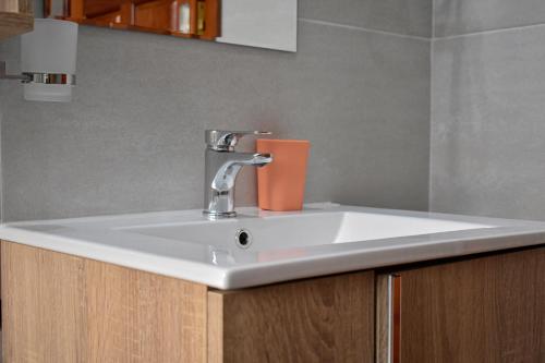 a white bathroom sink with an orange container on it at Forefront Self-Catering Apartments in Kitwe