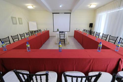a conference room with a red table with bottles of water on it at Hotel San Miguel, en el Centro - Desayuno Incluido in Tuxtla Gutiérrez