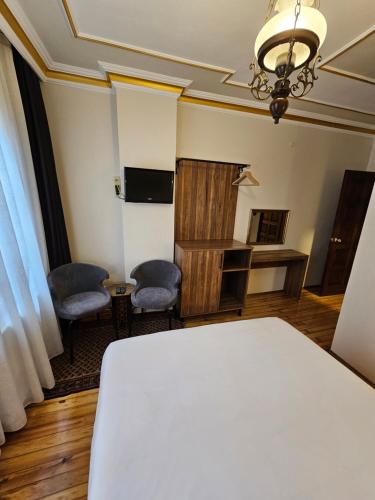 ein Zimmer mit einem weißen Bett und zwei Stühlen in der Unterkunft Gul Sultan Hotel in Istanbul