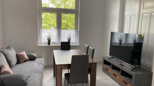 sala de estar con sofá, mesa y TV en Villa Mariensiel, en Sande