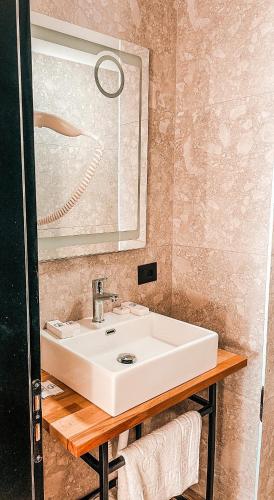 a bathroom with a white sink and a mirror at Gogo's Boutique Hotel in Dhërmi