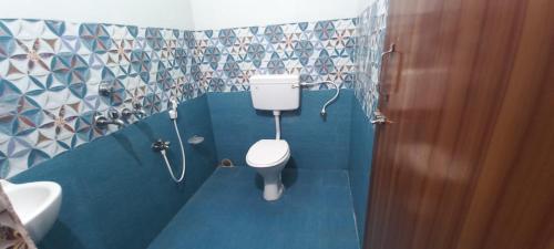 a small bathroom with a toilet and a sink at Goroomgo Neelachal Holiday Nibasa Puri in Puri