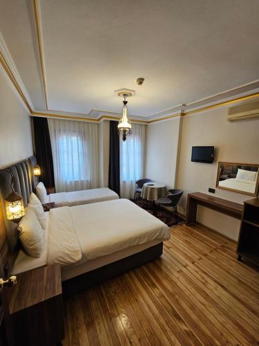 イスタンブールにあるGul Sultan Hotelの大きなベッドとデスクが備わるホテルルームです。