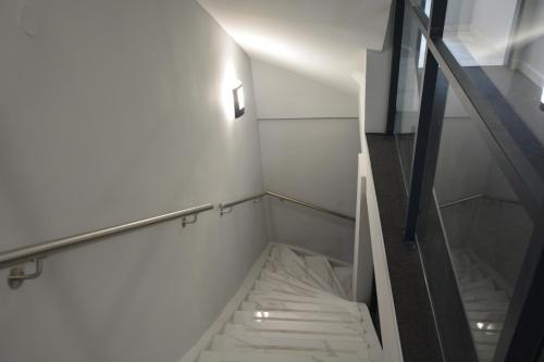 eine Treppe in einem Zimmer mit weißen Wänden in der Unterkunft Stadthotel Das Villach in Villach
