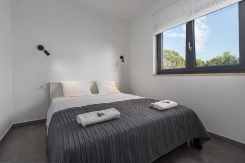 ein Schlafzimmer mit einem Bett, auf dem zwei Handtücher liegen in der Unterkunft Villa Antonina by SeeAdria Agency in Filipac
