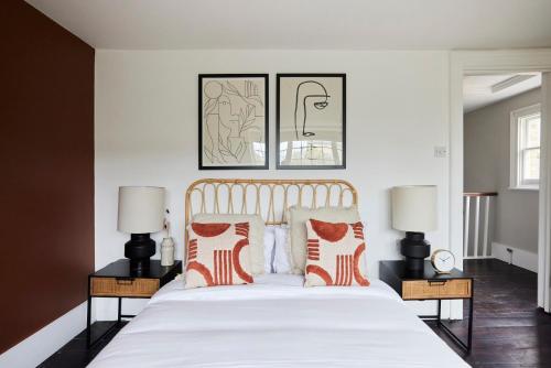 a bedroom with a large white bed with two lamps at The Southwark Townhouse - Adorable 3BDR House with Garden in London