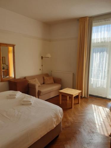 a hotel room with a bed and a couch at Landgoed Huize Glory in Bergen aan Zee