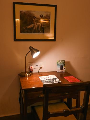 a desk with a lamp and a picture on the wall at Ranbanka Palace in Jodhpur