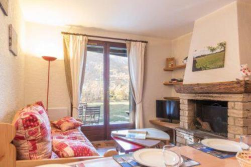 uma sala de estar com um sofá e uma lareira em Cocoon with garden and beautiful mountain view em Le Monêtier-les-Bains
