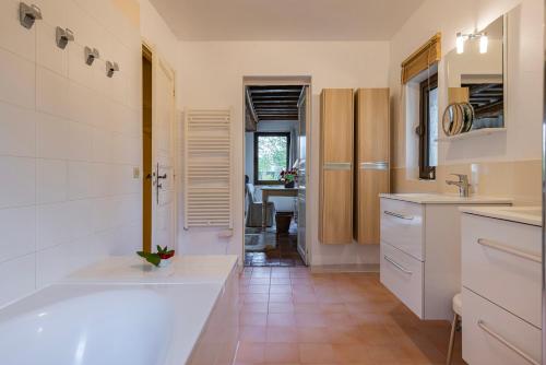 een keuken met een bad, een wastafel en een tafel bij Maison "Jardin Gaillard" in Biéville-en-Auge