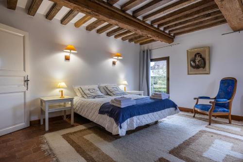 a bedroom with a bed and a blue chair at Maison "Jardin Gaillard" in Biéville-en-Auge