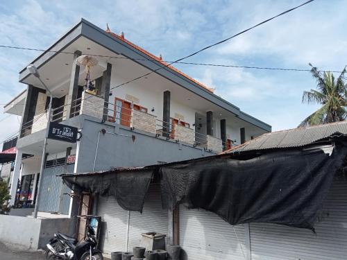 a white building with a black sheet hanging from it at D'TRANSIT in Nusa Penida