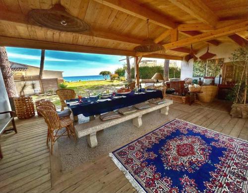 a patio with a table and chairs on a deck at Maison "LA ROSALINDA-2B" Ghisonaccia in Ghisonaccia