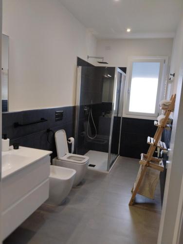 a bathroom with a toilet and a glass shower at Gioja suite in Quartu SantʼElena