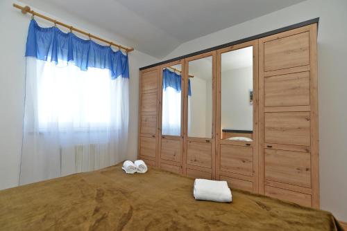 - une chambre avec un lit et une grande armoire en bois dans l'établissement Apartments Vili 351, à Fažana