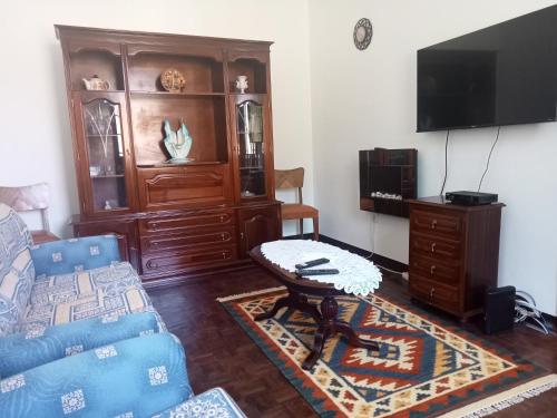 uma sala de estar com um sofá e uma televisão em Boaventura Hikers Comfort em Boaventura